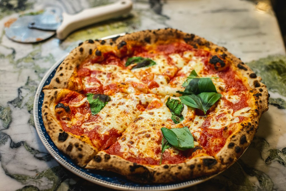 Pizza mit Tomaten, Mozzarella und Basilikum